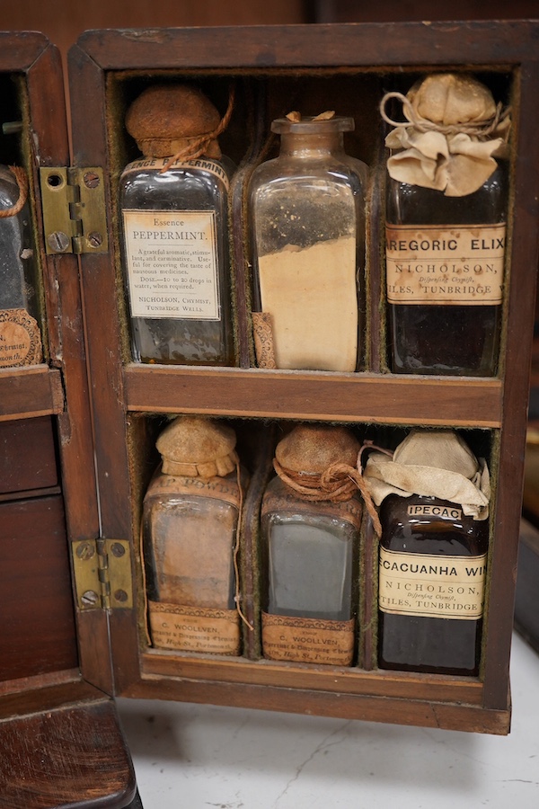 A 19th century mahogany apothecary cabinet, containing 20 bottles of various medicinal compounds and poisons, some sealed, all with paper labels, mainly for ‘C. Woollven, Operative & Dispensing Chemist, 108, High Street,